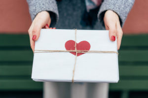 person holding an envelope with a red heart drawn on it