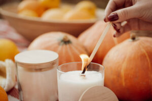 lit candle among pumpkins and gourds