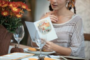 woman sits at holiday table reading card
