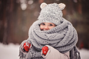 cozy outdoor portrait of happy toddler child girl in winter